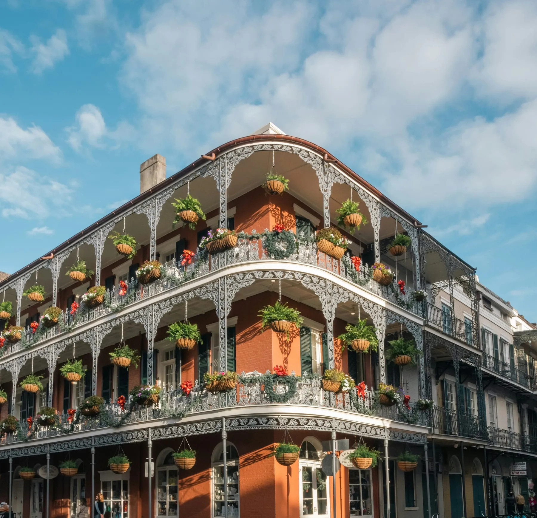 Wrought-iron balconies with hanging ferns on a French Quarter building in New Orleans
